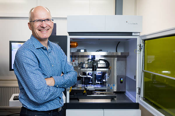 portrait of Erwin Vergeest with automated flip chip assembly machine